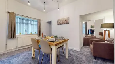 a living room with a table and chairs and a couch at Modernised 3-bedroom Blackburn townhouse sleeps 6 in Rishton