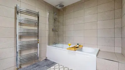 a bathroom with a tub and a glass shower at Modernised 3-bedroom Blackburn townhouse sleeps 6 in Rishton