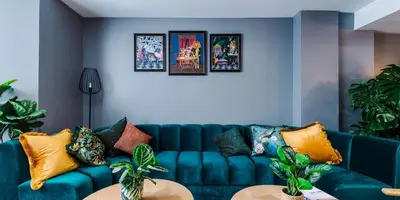 a blue couch in a living room with plants at City Studios, Preston in Preston