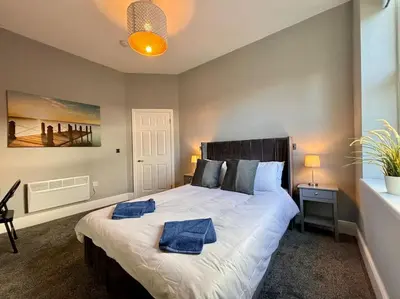 a bedroom with a large bed with blue towels on it at Teds Apartments - Town Centre - Apt 1 in Blackpool