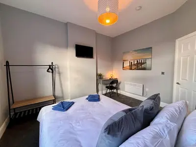 a bedroom with a large bed with blue towels on it at Teds Apartments - Town Centre - Apt 1 in Blackpool