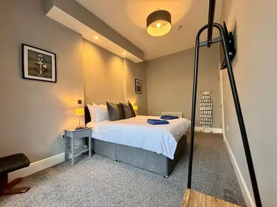 a bedroom with a large bed with a lamp on a table at Teds Apartments - Town Centre - Apt 2 in Blackpool