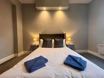 a bedroom with a large bed with blue towels on it at Teds Apartments - Town Centre - Apt 2 in Blackpool