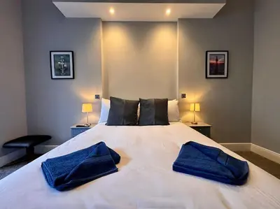 a bedroom with a large white bed with two blue pillows at Teds Apartments - Town Centre - Apt 2 in Blackpool