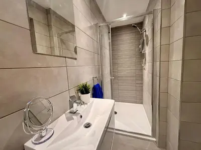 a white bathroom with a sink and a shower at Teds Apartments - Town Centre - Apt 2 in Blackpool