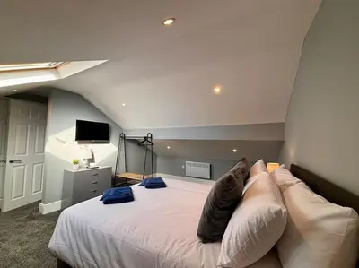 a bedroom with a large white bed with blue pillows at Teds Apartments - Town Centre - Apt 3 in Blackpool