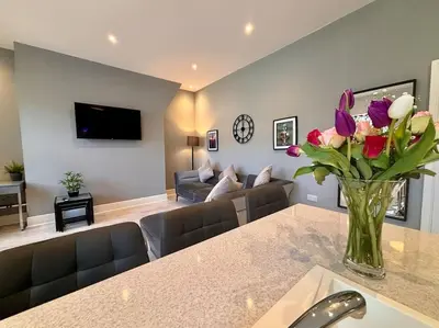 a living room with a vase of flowers on a table at Teds Apartments - Town Centre - Apt 3 in Blackpool