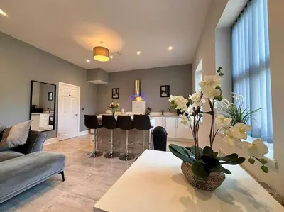 a living room with a couch and a table with flowers at Teds Apartments - Town Centre - Apt 3 in Blackpool