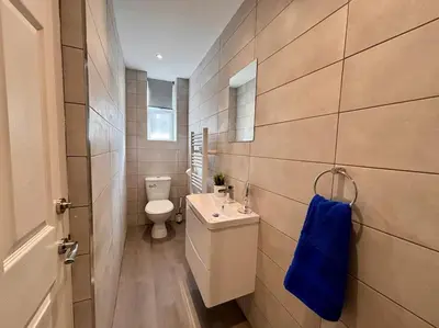 a bathroom with a toilet and a blue towel at Teds Apartments - Town Centre - Apt 3 in Blackpool