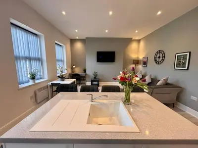 a kitchen with a sink and a living room at Teds Apartments - Town Centre - Apt 3 in Blackpool