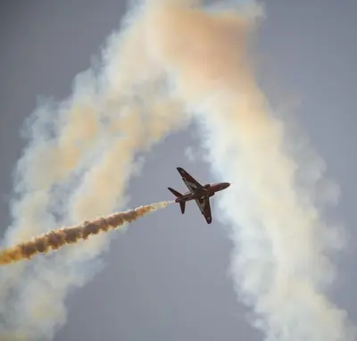 an airplane flying in the sky with smoke at Home Farm Cottage in Lytham St Annes