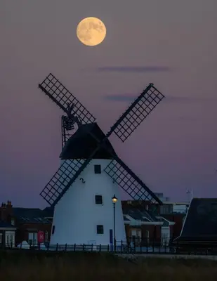 a windmill with the moon in the sky behind it at Home Farm Cottage in Lytham St Annes