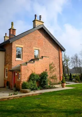 a brick house with stairs on the side of it at Home Farm Cottage in Lytham St Annes