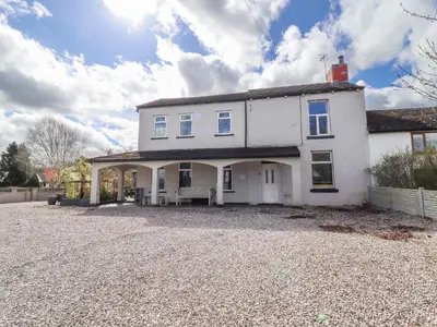 a large white house with a gravel driveway at Pendle View Apartments in Blackburn