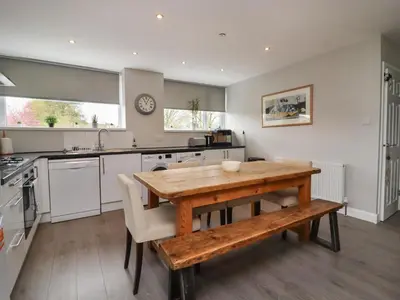 a kitchen with a wooden table and a wooden bench at Pendle View Apartments in Blackburn