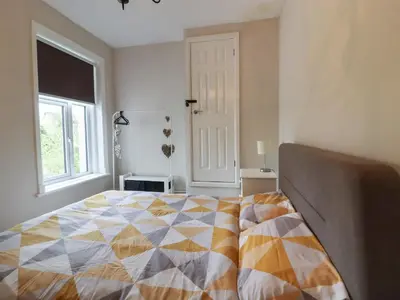 a bedroom with a bed with a colorful quilt on it at Pendle View Apartments in Blackburn
