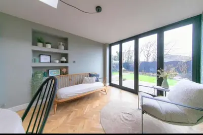 a living room with a couch and a large window at Beautifully styled Home with Garden in Poulton le Fylde