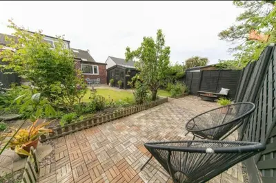 a backyard with a fence and a brick patio at Beautifully styled Home with Garden in Poulton le Fylde