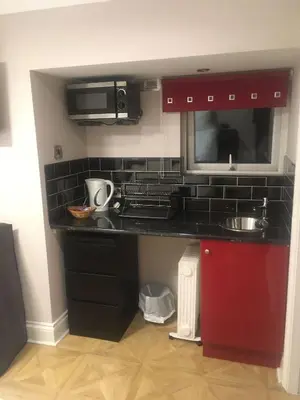a kitchen with a black counter and a microwave at Aachen Hotel in Liverpool