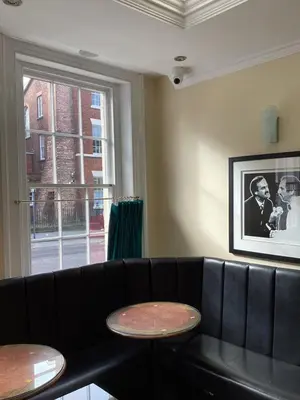 a living room with a black couch and two tables at Aachen Hotel in Liverpool