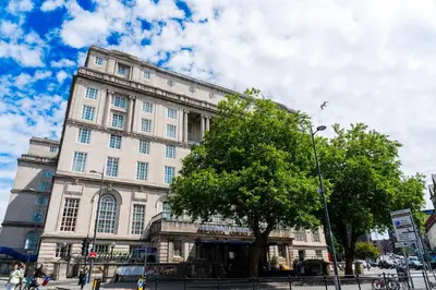 a large building with a tree in front of it at Adelphi Hotel in Liverpool