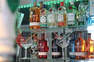 a bunch of bottles of alcohol on shelves with glasses at Adelphi Hotel in Liverpool