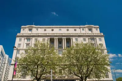 a white building with two trees in front of it at Adelphi Hotel in Liverpool