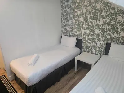a small room with two beds and a chair at ROSE in Blackpool