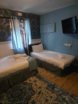 a room with two beds and a flat screen tv at ROSE in Blackpool