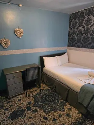 a small bedroom with a bed and a desk at ROSE in Blackpool
