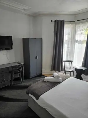 a bedroom with a bed and a desk and a tv at ROSE in Blackpool