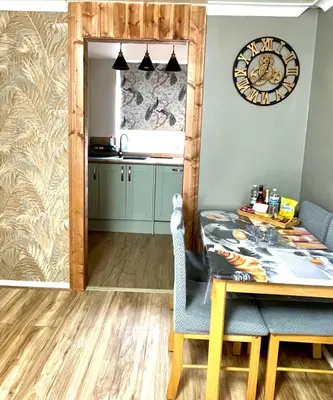 a kitchen with a table and a clock on the wall at Modern Luxury apartment Liverpool in Liverpool