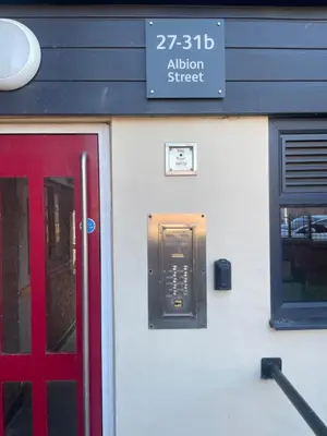 a red door and a sign on the side of a building at Modern Luxury apartment Liverpool in Liverpool