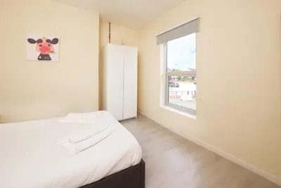 a bedroom with a bed and a window at GuestReady Modern 2BR Home by Anfield Stadium in Liverpool