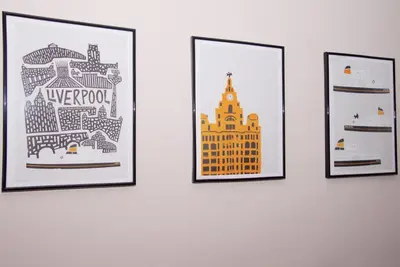 a group of four framed pictures on a wall at GuestReady Modern 2BR Home by Anfield Stadium in Liverpool