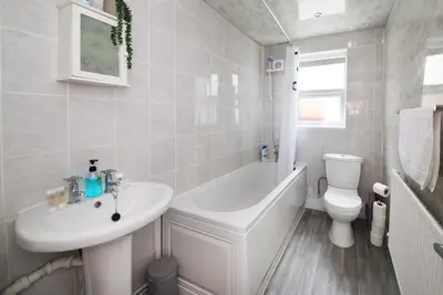 a bathroom with a sink and a tub and a toilet at GuestReady Modern 2BR Home by Anfield Stadium in Liverpool