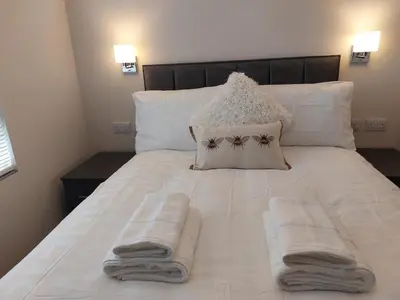 a white bed with towels on top of it at Sunnydale, Cartmel in Cartmel