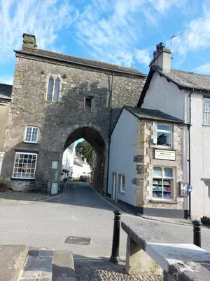an old stone building with an archway on a street at Sunnydale, Cartmel in Cartmel