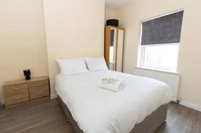 a bedroom with a large white bed with two towels on it at Seaside Retreat - 2BR Apt in Southport in Southport