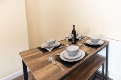 a wooden table with glasses and a bottle of wine at Seaside Retreat - 2BR Apt in Southport in Southport