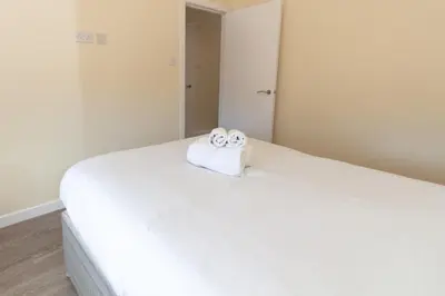 a white bed with two towels on top of it at Seaside Retreat - 2BR Apt in Southport in Southport