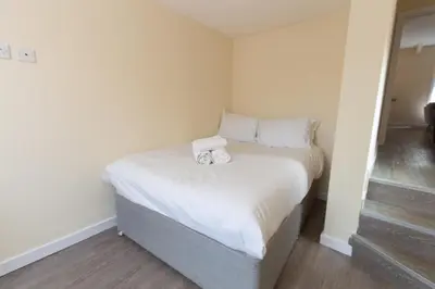 a small bedroom with a bed with two towels on it at Seaside Retreat - 2BR Apt in Southport in Southport
