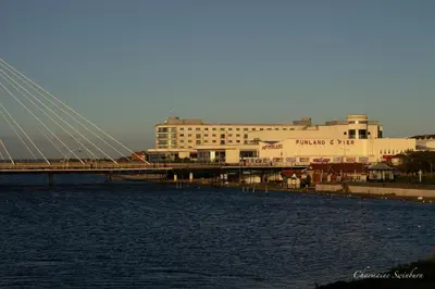 a bridge over a body of water with a building at Seaside Retreat - 2BR Apt in Southport in Southport