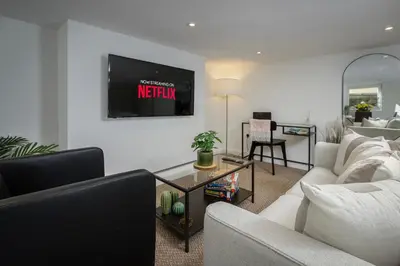 a living room with a couch and a tv on the wall at Blackpool Central Springfield Apartments Spacious Comfort in Blackpool