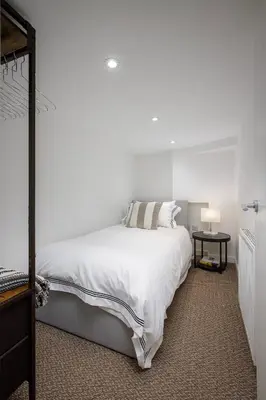 a white bedroom with a bed and a table at Blackpool Central Springfield Apartments Spacious Comfort in Blackpool