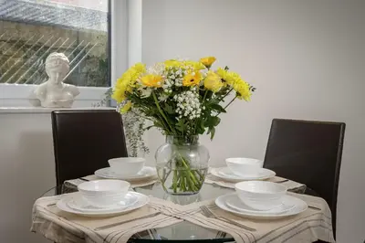 a glass table with a vase of flowers on it at Blackpool Central Springfield Apartments Spacious Comfort in Blackpool