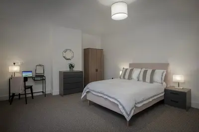 a bedroom with a bed and a desk with a mirror at Blackpool Central Springfield Apartments Spacious Comfort in Blackpool