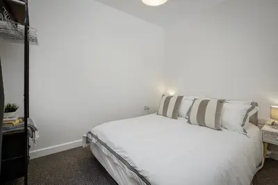 a bedroom with a white bed with two pillows at Blackpool Central Springfield Apartments Spacious Comfort in Blackpool