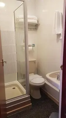 a bathroom with a toilet and a shower and a sink at Valdene Hotel in Blackpool