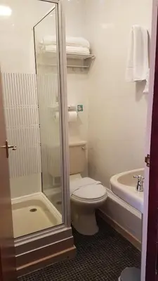 a bathroom with a toilet and a shower and a sink at Valdene Hotel in Blackpool